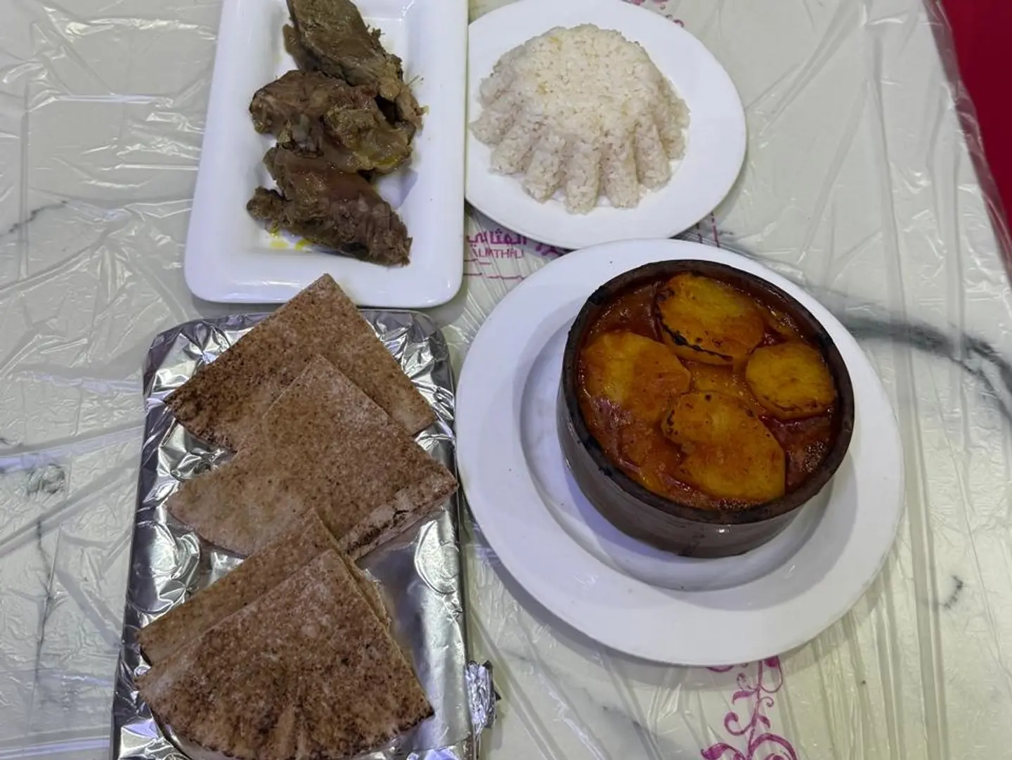 A Delicious Meal Featuring Boiled Veal Potatoes White Rice And A Single Grain Bread Roll