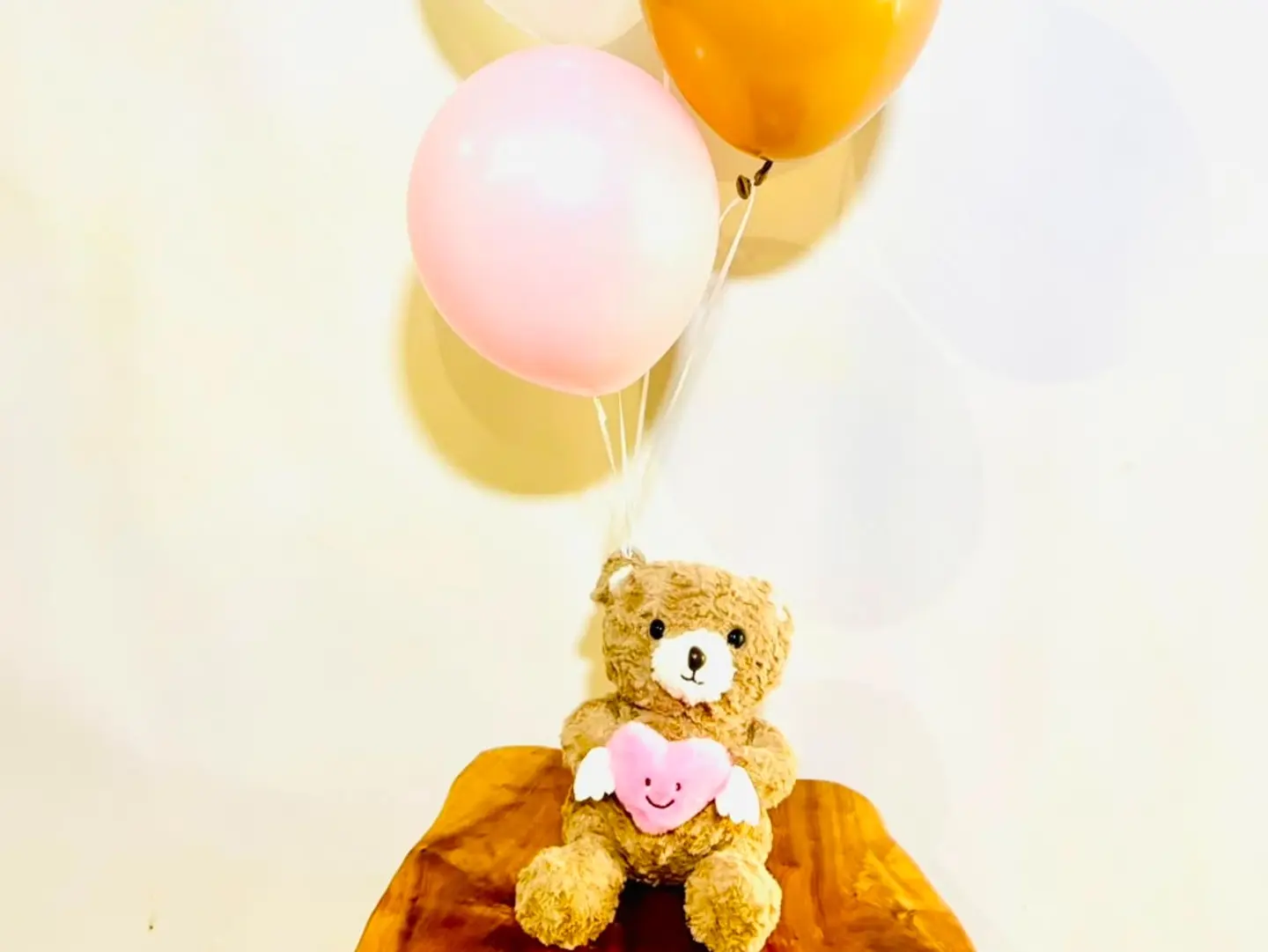 A Small Brown Bear With Balloons