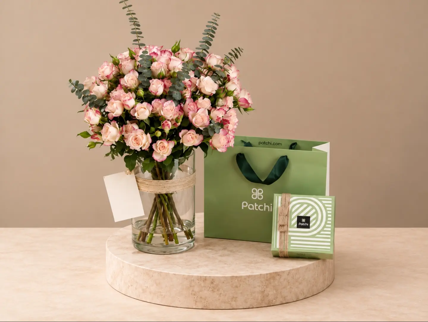 A Vase With White Flowers And Patchi Chocolates