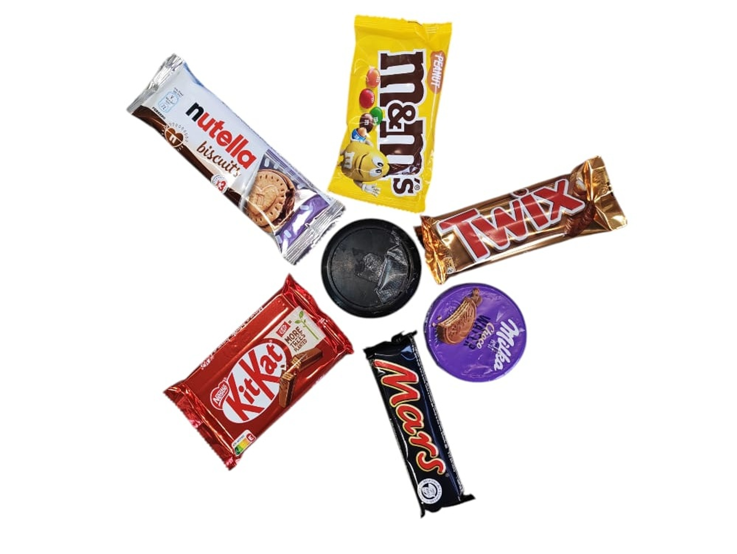 A Diverse Assortment Featuring One Of Each Yellow M&Ms, Nutella Biscuits, 4 Finger Kit Kat, Round Milka, Large Mars, And Large Twix.