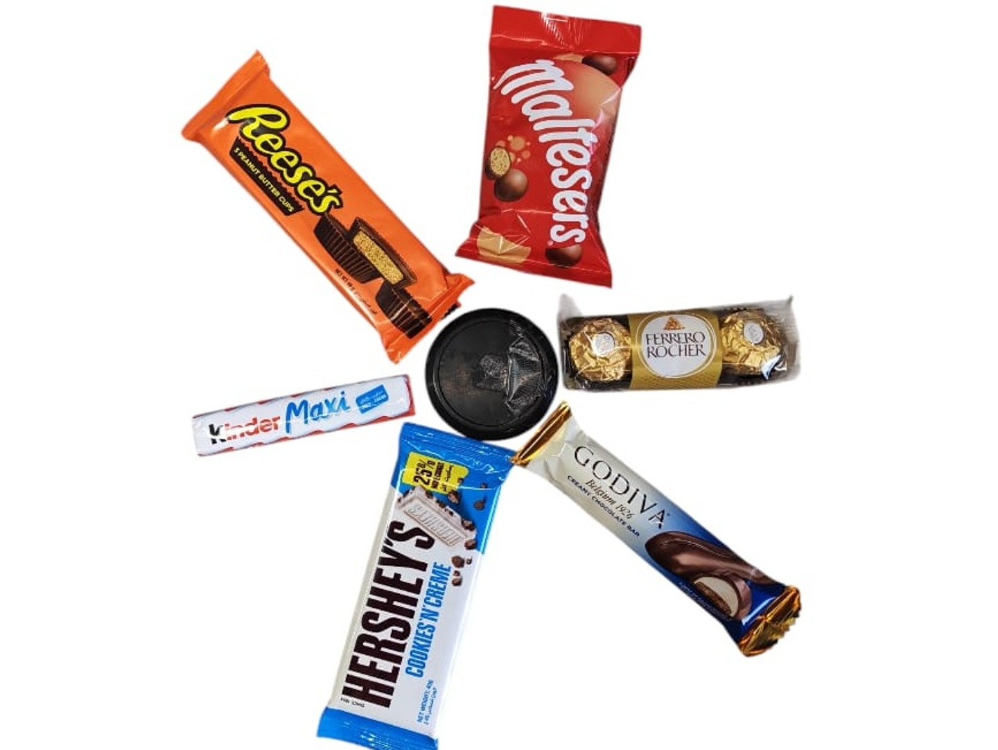An Assortment Featuring A Variety Of Treats Maltesers, Kinder Maxi, Godiva, Hershey's, Reese's Cups, And Ferrero Rocher.
