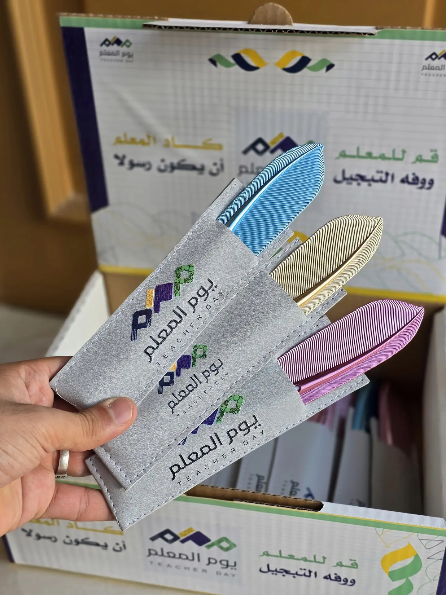 A Box Containing 24 Pens Inside A Leather Wallet With The Teacher's Day Logo.