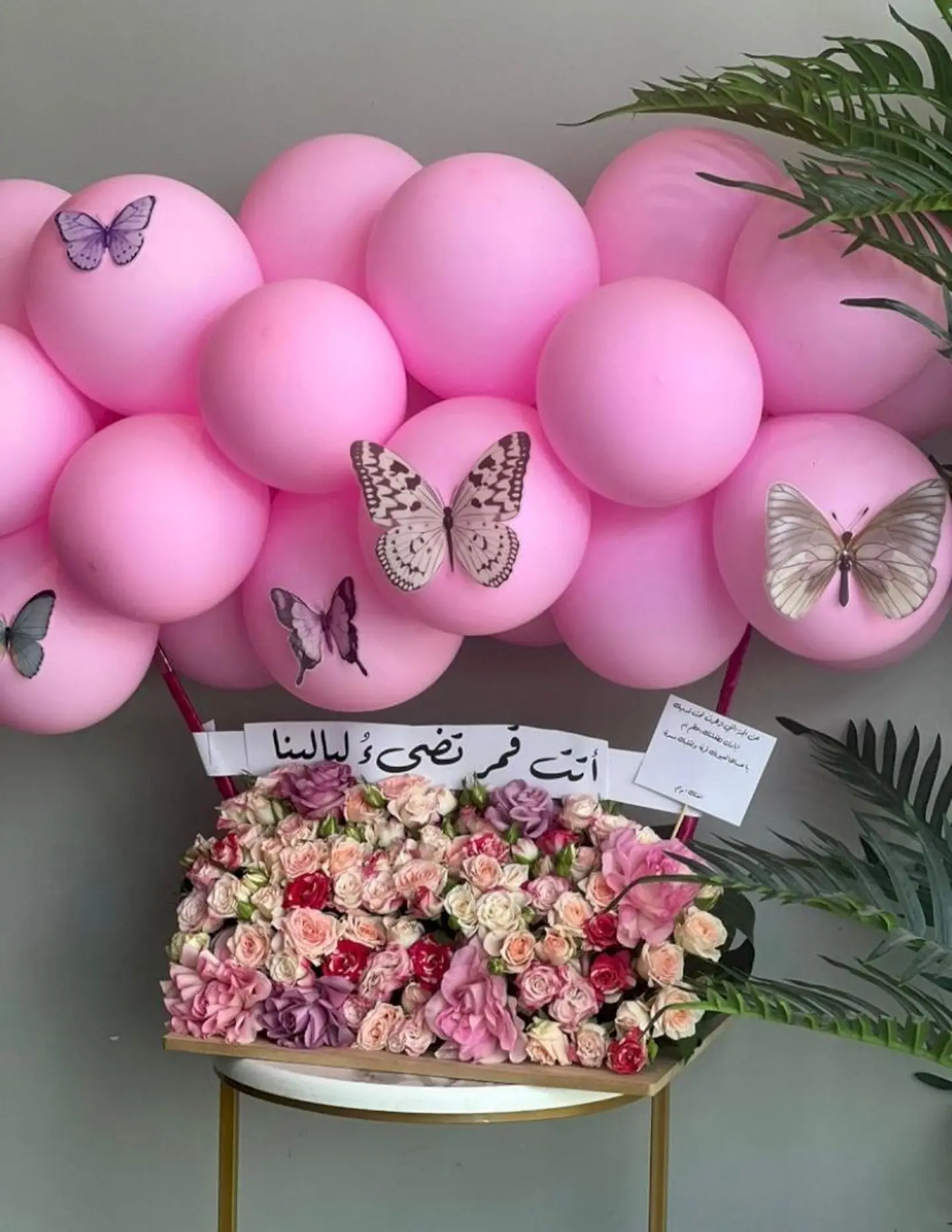 تنسيق مولودة ورد بالون وفراشات على لوح خشب